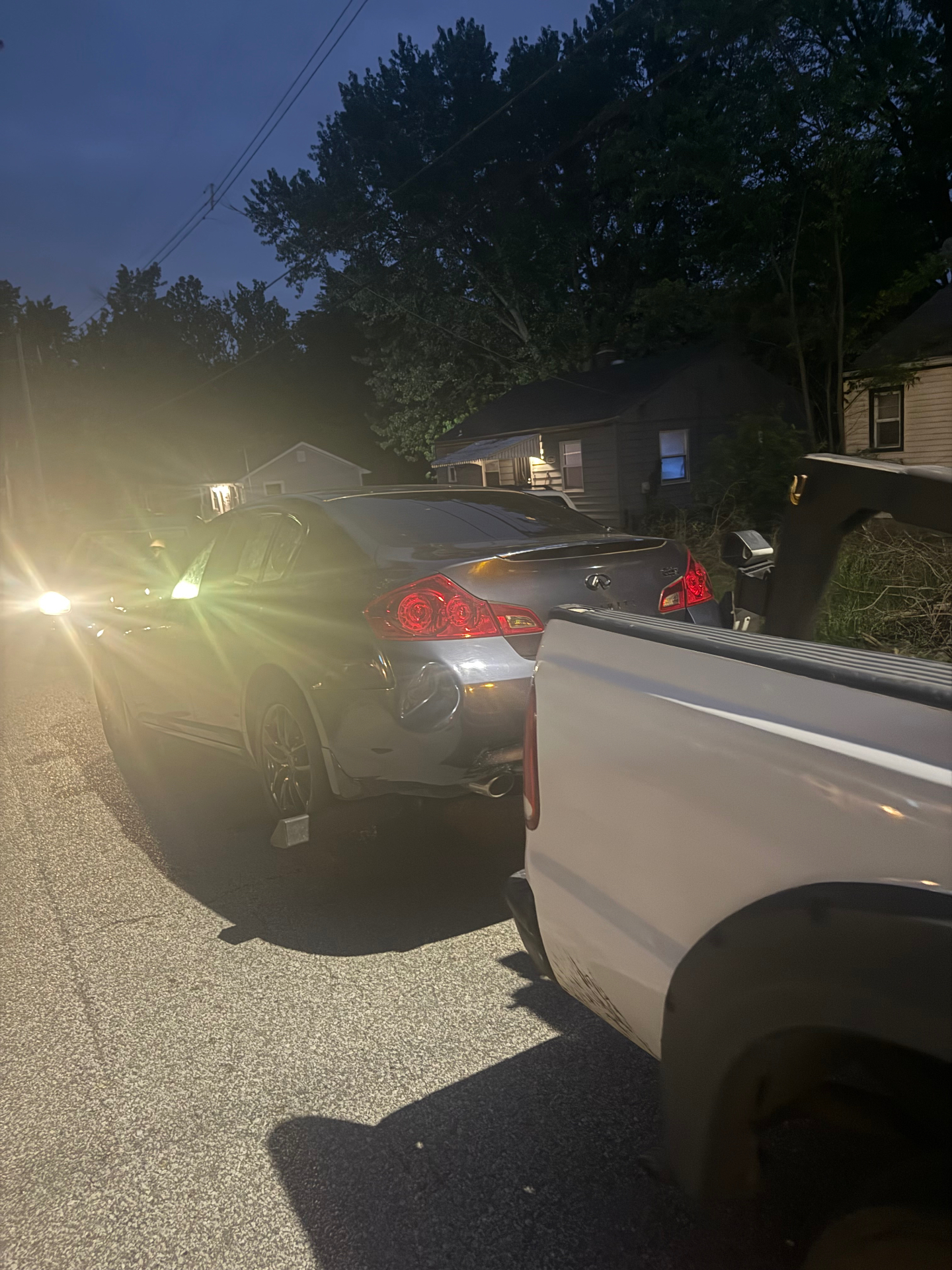 Nighttime junk vehicle tow in a neighborhood