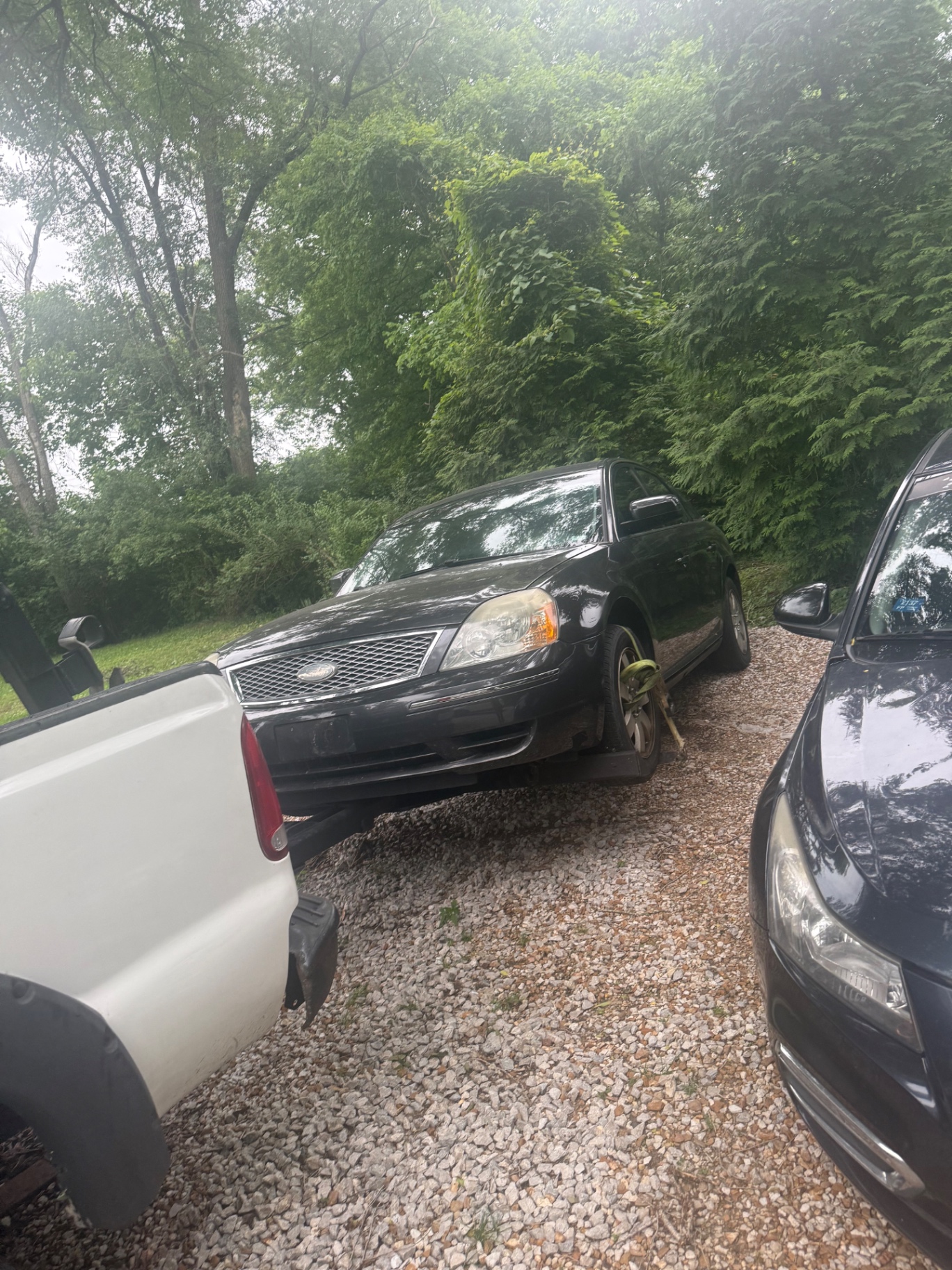 Black sedan being loaded for junk car removal
